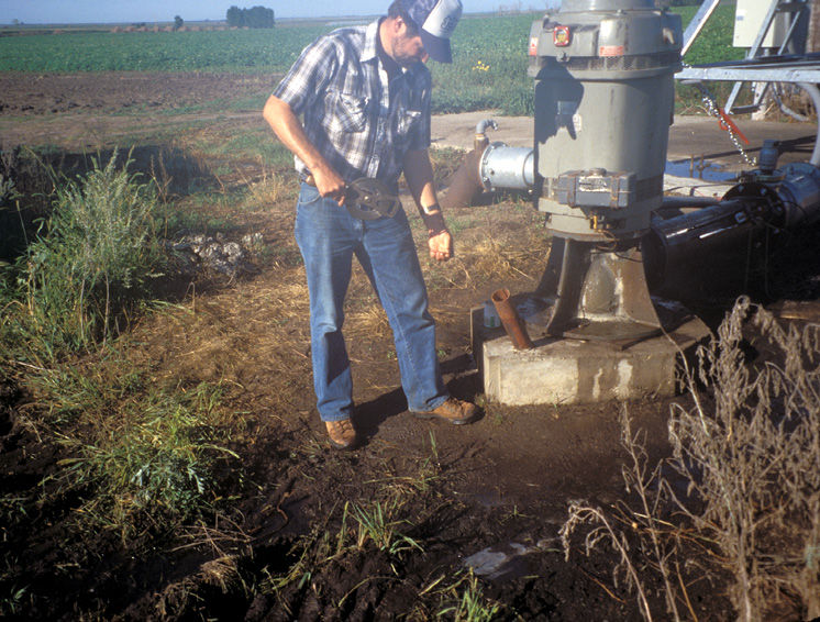 man measuring water level in a well