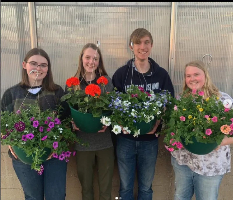 students pose with planters they created