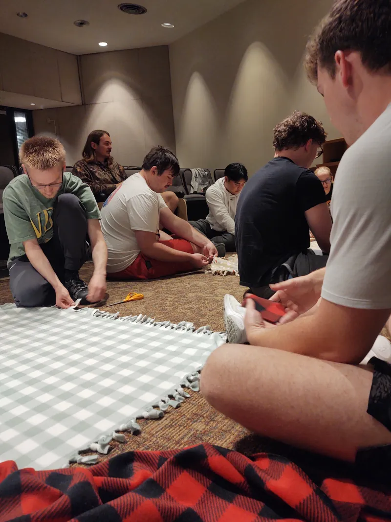 Students making tie blankets together in Van Es (the microbiological sciences main building on campus).