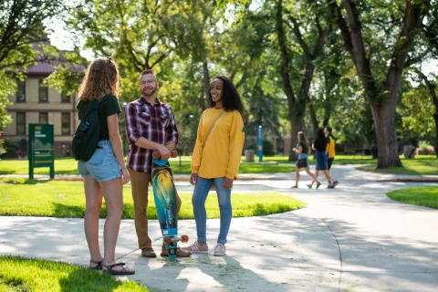 three students talking to each other on campus